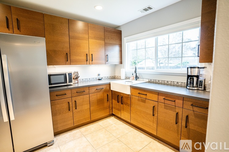 A kitchen with wooden cabinets and a stainless steel refrigerator.