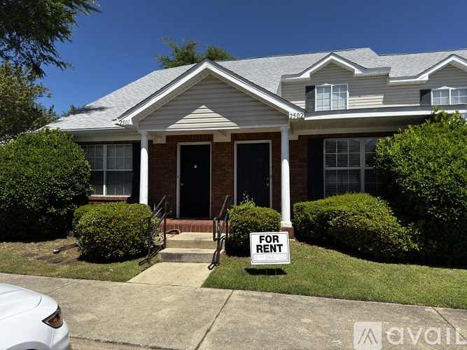 A house with a "For Rent" sign in front.