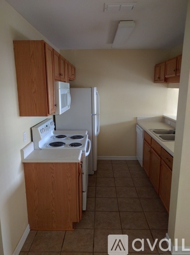 A kitchen with a stove, refrigerator, and cabinets.