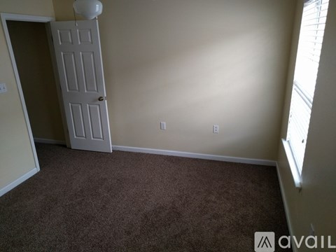A room with a carpeted floor and a white door.