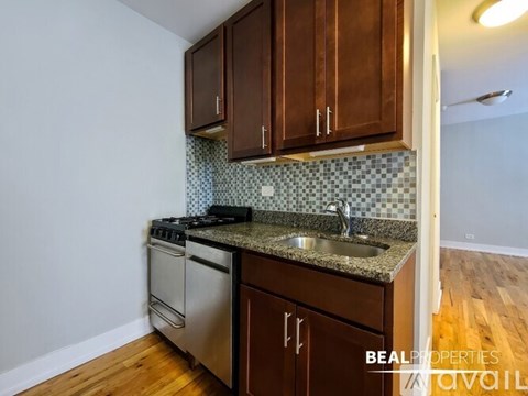 A kitchen with wooden cabinets and a tile backsplash.