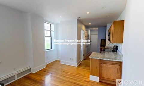 A kitchen area with wooden floors and a countertop.