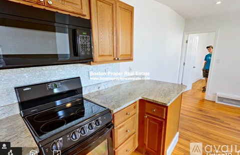 A kitchen with a stove, microwave, and cabinets.