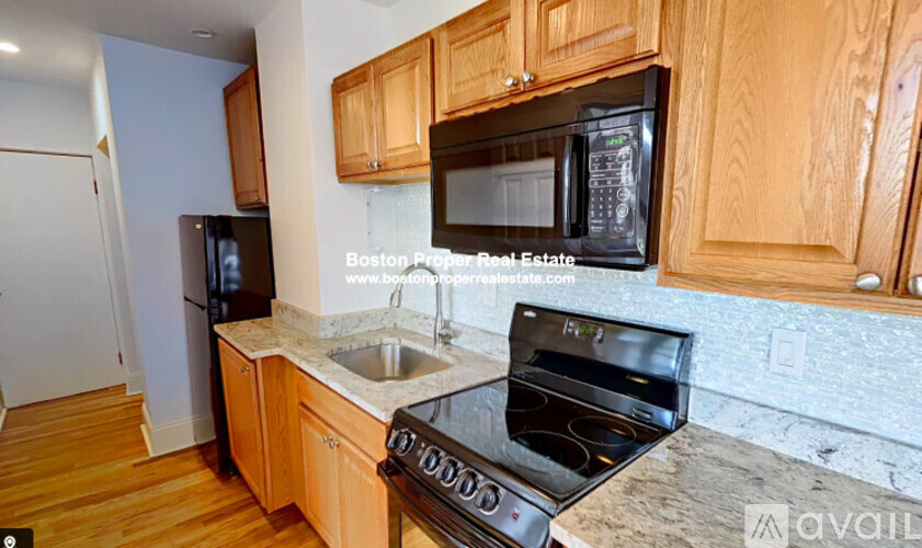 A kitchen with wooden cabinets and a black stove top oven.