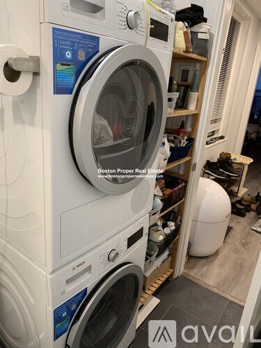 A white washing machine with a blue label on it.