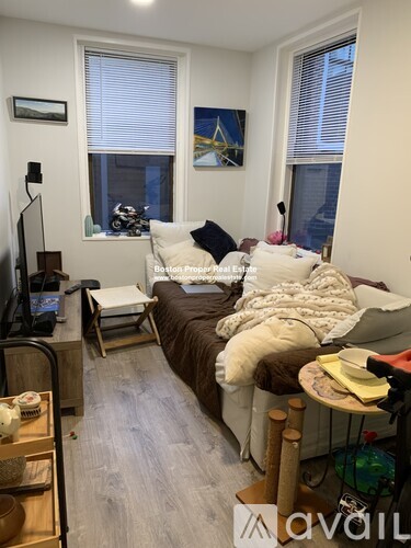 A living room with a couch, chair, and television.