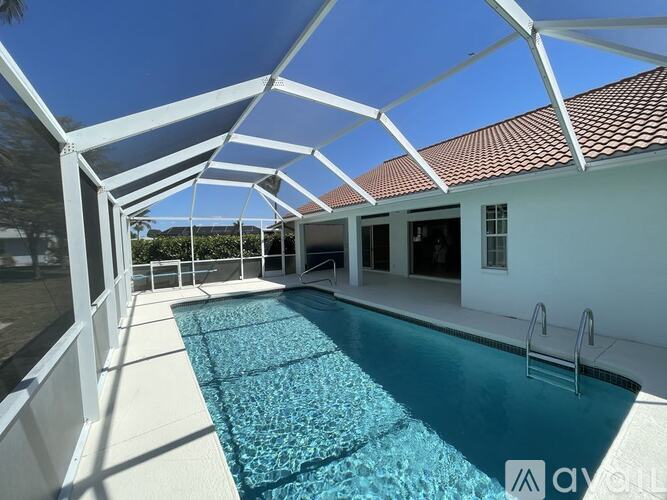 A pool under a white roof with a ladder.