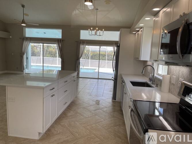 A modern kitchen with white cabinets and a large island.
