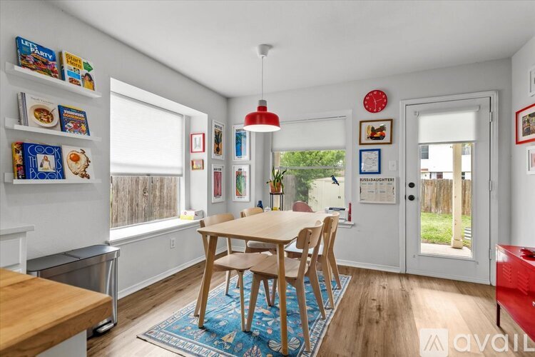 A dining room with a table and chairs and a bookshelf.