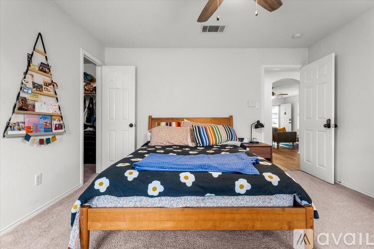 A bedroom with a bed covered in a blue floral comforter.