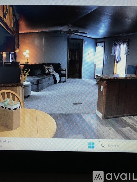 A living room with a couch, a chair, and a television.