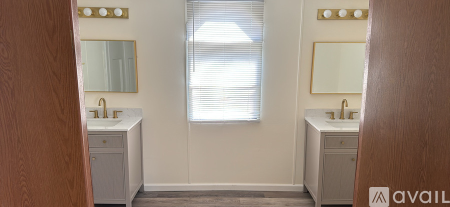 A bathroom with two sinks and a large mirror.