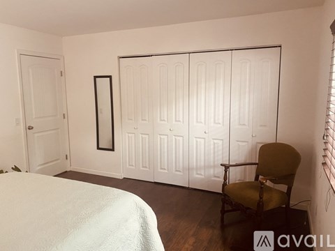 A white toilet sits under a shower curtain in a bathroom.