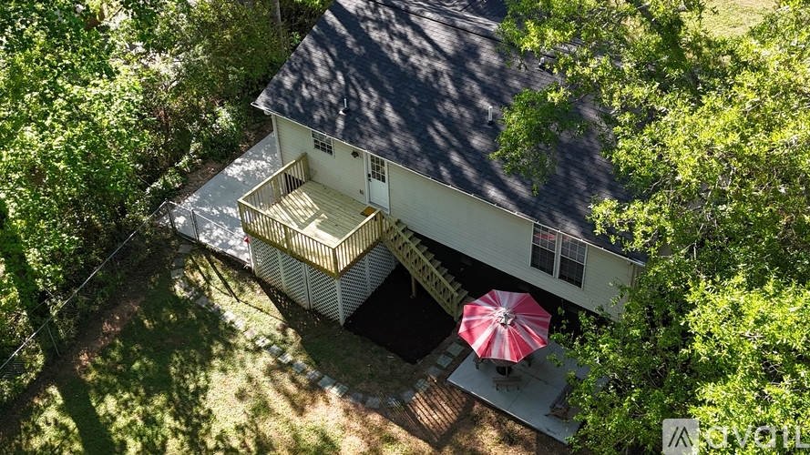 A house with a deck and a red umbrella.