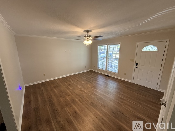 A room with wooden flooring and a ceiling fan.