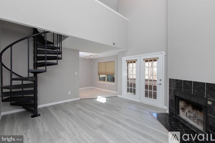 A living room with a fireplace and a spiral staircase.