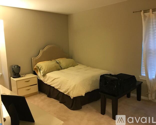 A bedroom with a bed, nightstand, and chair.