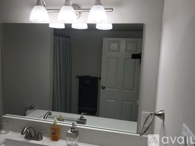 A bathroom with a sink, mirror, and lights.