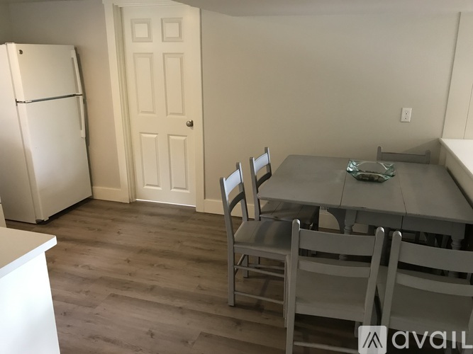 A kitchen with a table and chairs.