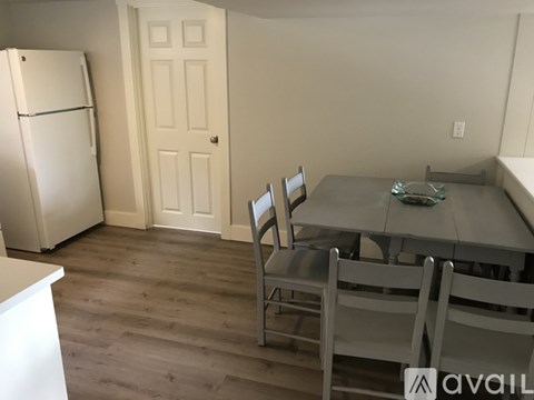 A kitchen with a table and chairs.