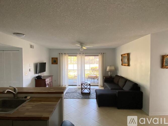 A living room with a black couch and a wooden table.
