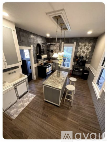 A kitchen with a white fridge and a marble island.