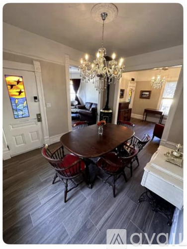 A dining room with a wooden table and chairs.