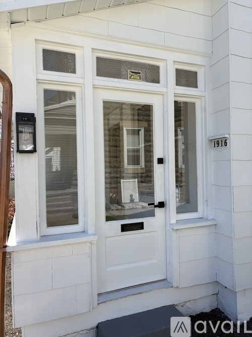 A white door with a glass window and a mailbox on the side.