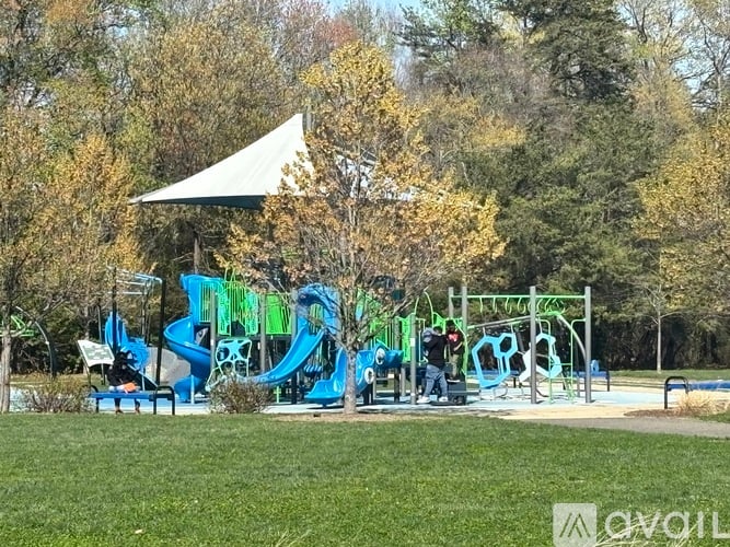A playground with a blue slide and a white canopy.