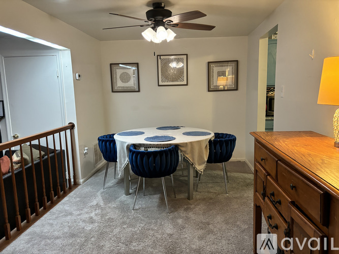 A dining room with a round table and chairs.