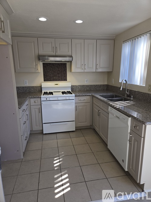 A kitchen with white appliances and cabinets.