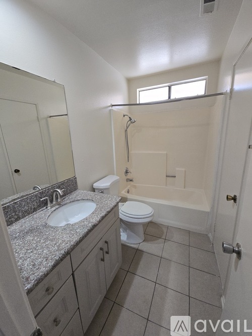 A bathroom with a sink, toilet, and bathtub.