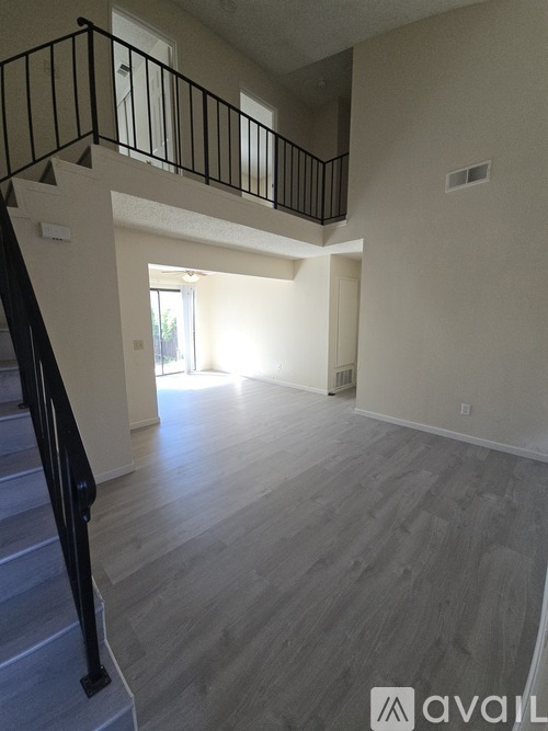 A spacious living room with a staircase leading to the upper floor.