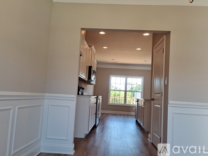 A kitchen with white cabinets and a window.