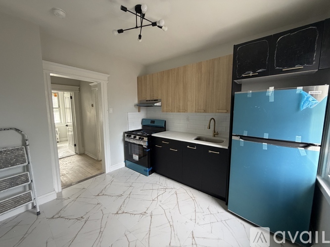 A kitchen with a blue fridge and wooden cabinets.