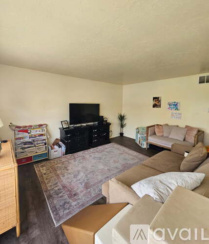 A living room with a couch, a television, and a plant.