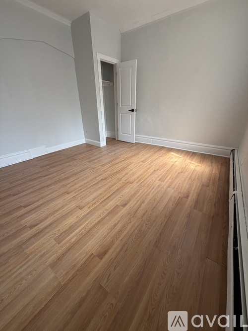 A room with wooden flooring and a white door.