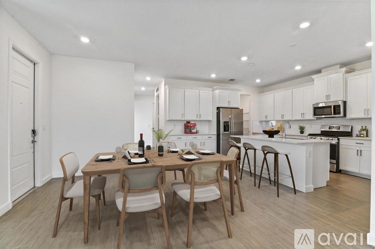 A modern kitchen with a dining table set for four.