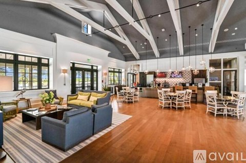 A spacious living room with a variety of furniture and a striped rug.