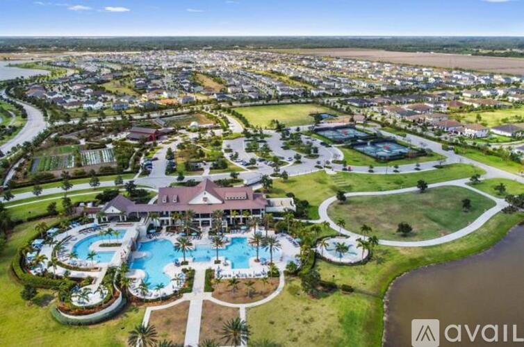 An aerial view of a resort with a swimming pool and palm trees.