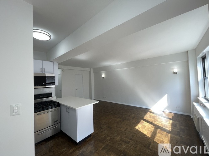 A kitchen with a white island and stainless steel appliances.