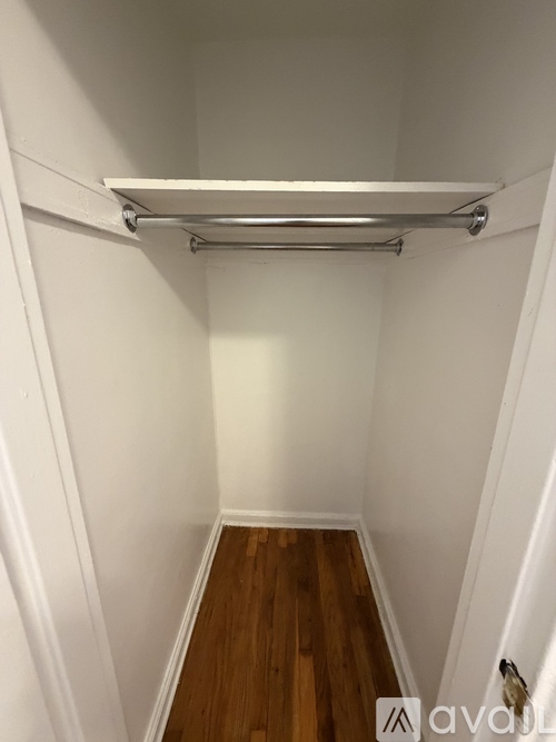 A white closet with a white shelf and a white rail.