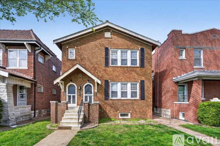 A red brick house with a white door and windows.