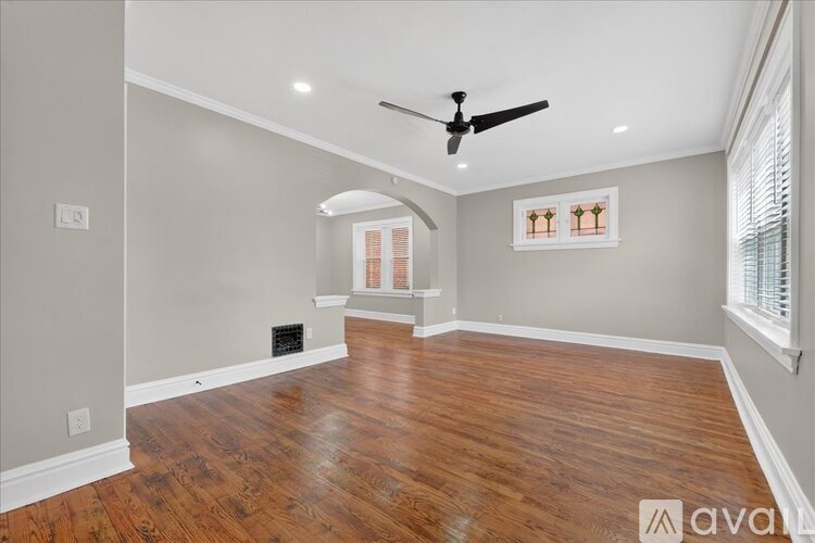 A room with wooden flooring and a ceiling fan.