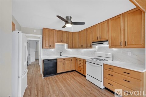 A kitchen with wooden cabinets and a white fridge.