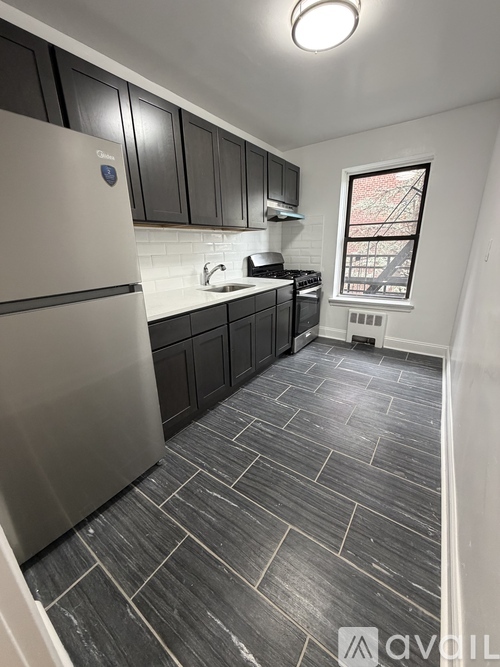 A kitchen with a white fridge and black cabinets.