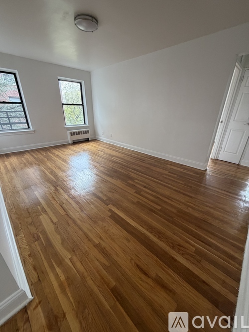A room with wooden flooring and a window.