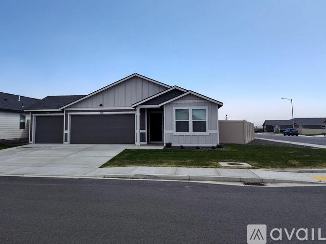 A house with a grey garage door is for sale.