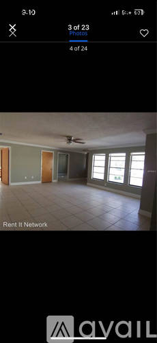 A room with a ceiling fan and large windows.