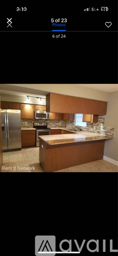 A kitchen with brown cabinets and a stone backsplash.